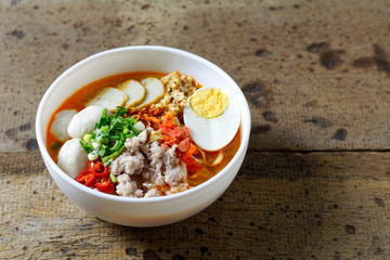 Spicy tom yam pork noodle soup with lemongrass, chili paste, boiled egg and lime juice