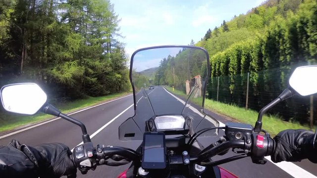 Motorcyclist Riding on the Beautiful Empty Road near Green Trees and Hills