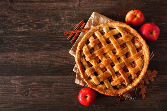 Homemade autumn apple pie, top view with frame of ingredients on a dark wood table with copy space