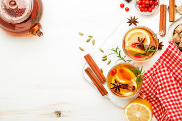 Winter autumn warming hot tea with lemon, cranberries and spices, white background, copy space, top view