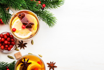 Winter hot tea with lemon, cranberries and spices for Christmas or New Year evening, white background, copy space, top view