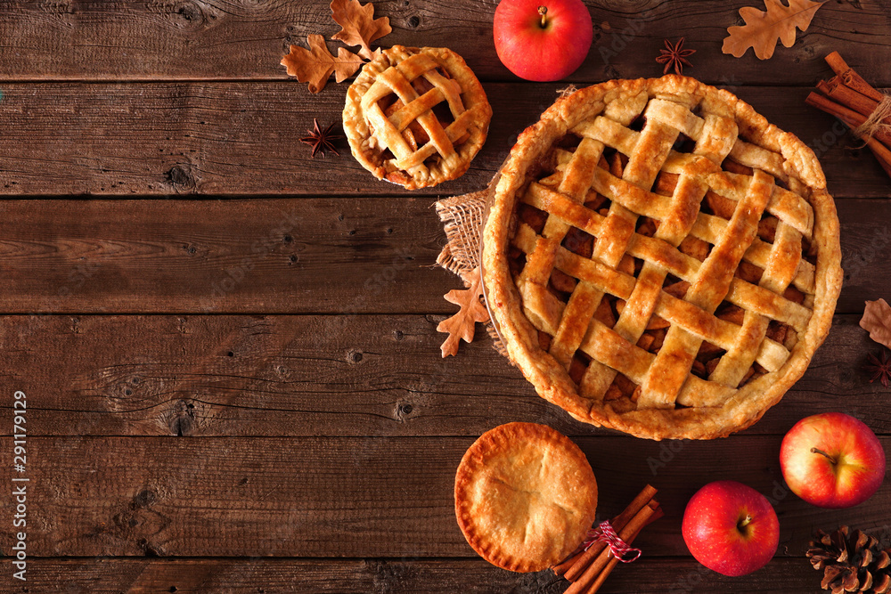 Poster Homemade autumn apple pie corner border. Top view table scene over a rustic wood background with copy space.