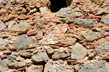 Fragment of an ancient wall illuminated by the bright sun close-up. Stone wall background.