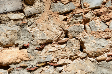 Fragment of an ancient wall illuminated by the bright sun close-up. Stone wall background.