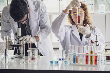 Team of Medical Research Scientist Conducts Experiments in Laboratory with Microscope, Test Tubes, Micropipette and other equipment.