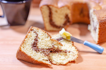 Breakfast table or afternoon with a delicious cake mixed with orange and chocolate accompanied by coffee and butter.
