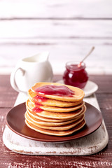 Tasty breakfast. Pancakes with strawberry confiture and butter.