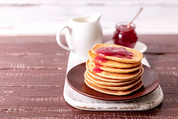 Tasty breakfast. Pancakes with strawberry confiture and butter.