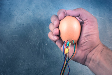 Cyber technology concept. Egg with wires in a male hand. Getting a new life with cybernetic technologies idea.