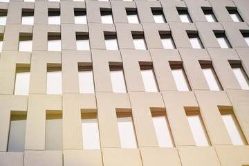 Perspective view of geometric angular concrete windows on the facade of a modernist brutalist style building.