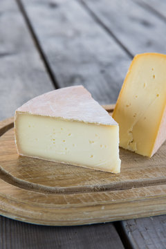 Cheese wedge over wood cutting board.