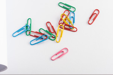 multicolored paper clips on an open blank paper