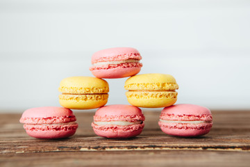 Sweet colorful French macaroon cookies dessert on brown wooden table