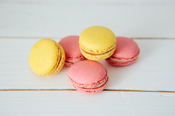 Sweet colorful French macaroon cookies dessert on white wooden table