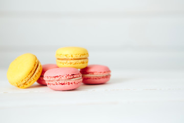Sweet colorful French macaroon cookies dessert on white wooden table