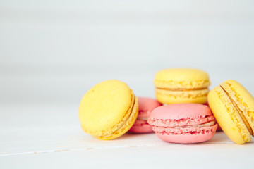 Sweet colorful French macaroon cookies dessert on white wooden table