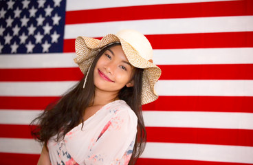 beautiful long black hair woman with a hat fashion posing indoors against american flag