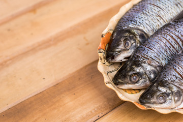 fresh fish served on a plate on a wooden table
