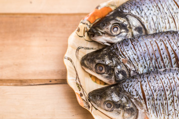 fresh fish served on a plate on a wooden table