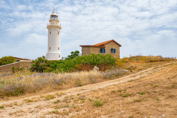 Fototapeta na wymiar Cyprus. Pathos. Archaeological Park of Paphos. Paphos lighthouse on the Mediterranean coast. Lighthouse and caretaker's house. Cyprian archaeological memorial. Sightseeing Cyprus. Travel to Cyprus.