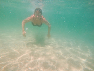 Fototapeta na wymiar Underwater photo of woman swimming in the sea