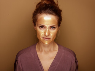 Fototapeta premium modern housewife with golden mask isolated on beige