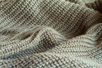 Close-up olive color knitted sweater made of natural wool texture, wavy folds, selective focus