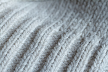 Extreme close-up gray color knitted sweater made of natural wool texture, wavy folds, selective focus