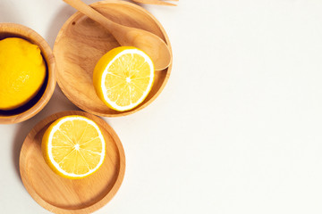 tropical fruit fresh natural lemon with wood cup dish and spoon fork, kitchen table isolated background, organic food and nutrition vitamin citrus, diet and healthy