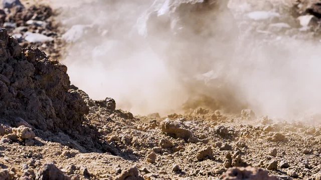 Slow motion close up footage of a lava rock falling on a lava dirt.Smoke and dust rising high up,at Teide National Park ,Tenerife,Canary island,Spain.