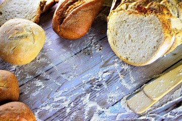 Variedades de pan expuesto sobre tabla de madera, estilo rustico