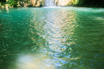 Beautiful view of turquoise color water surface, natural pool, secret place,  waterfall in forest at summer day