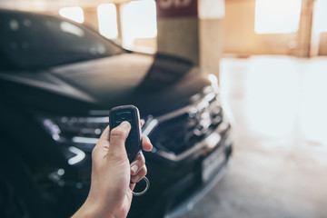 Hand presses unlock on the car remote control.