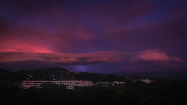 Raio de trovoada na cidade com nuvens dram&aacute;ticas na hora azul