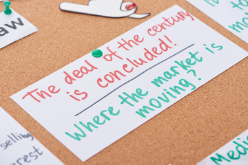 card with work notes pinned on cork office board