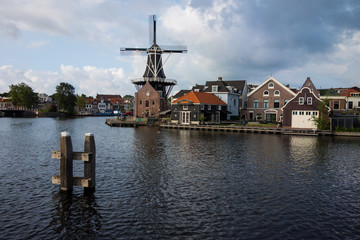 Fototapeta na wymiar Historische Windmühle an Haarlemer Gracht vor dramatischer Wolkenstimmung