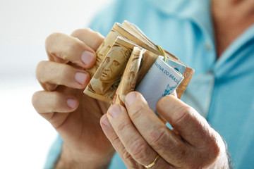 Hands holding Brazilian real notes - Money from Brazil - Notes of Real - Brazil BRL banknote