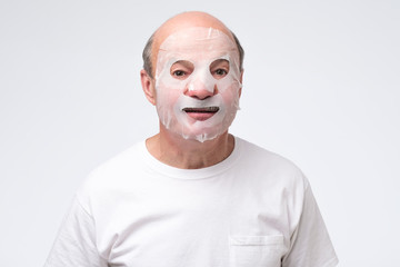 Hispanic mature man in a cosmetic mask skin care. Studio shot. take care about health at old age.