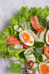 fresh  gourmet salad with  red  salmon caviar and  eggs and vegetables.  Protein luxury delicacy  healthy food. beautifull served at white table.