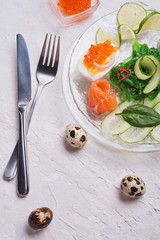 fresh  gourmet salad with  salmon, caviar, eggs , chuka and vegetables. served on white table.   Protein luxury delicacy  healthy food. beautifull served.  close up