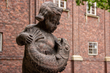 Statue of boy holding a fish in Stockholm