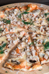 pizza with ham and mushrooms on a wooden plate