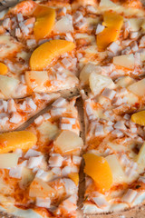 hawaiian pizza with ham and pineapples on a wooden platehavaian pizza with ham and pineapples on a wooden plate