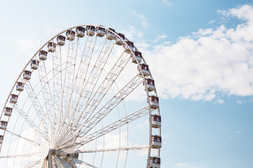 Ferris wheel close-up against blue sky background