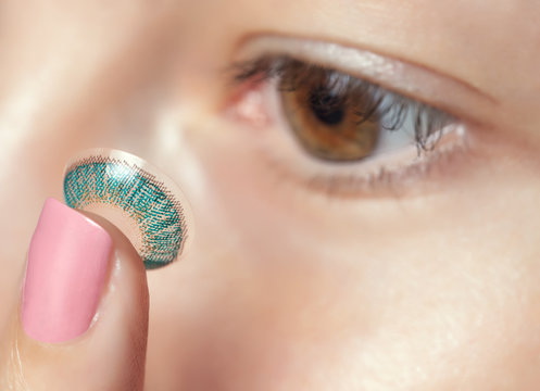 One Woman Holds A Blue Contact Lens On Her Finger. Eye Care And The Choice Between The Means To Improve Vision.