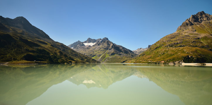 Scenic alpine landscape in summer. Silvretta Reservoir with mountain reflection, Vorarlberg, Austria. 