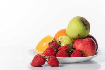 Fototapeta na wymiar fruits on a plate on a white background