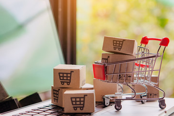 Shopping online concept - Parcel or Paper cartons with a shopping cart logo in a trolley on a...