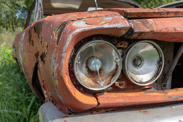 Fototapeta na wymiar Headlight of an old rusty abandoned car, utilisation and scrap concept