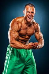 Fototapeta na wymiar Handsome, Strong BodyBuilder Flexing Muscles
